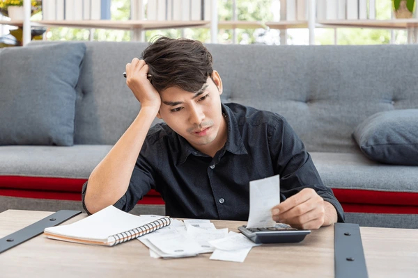 serious asian man calculating budget